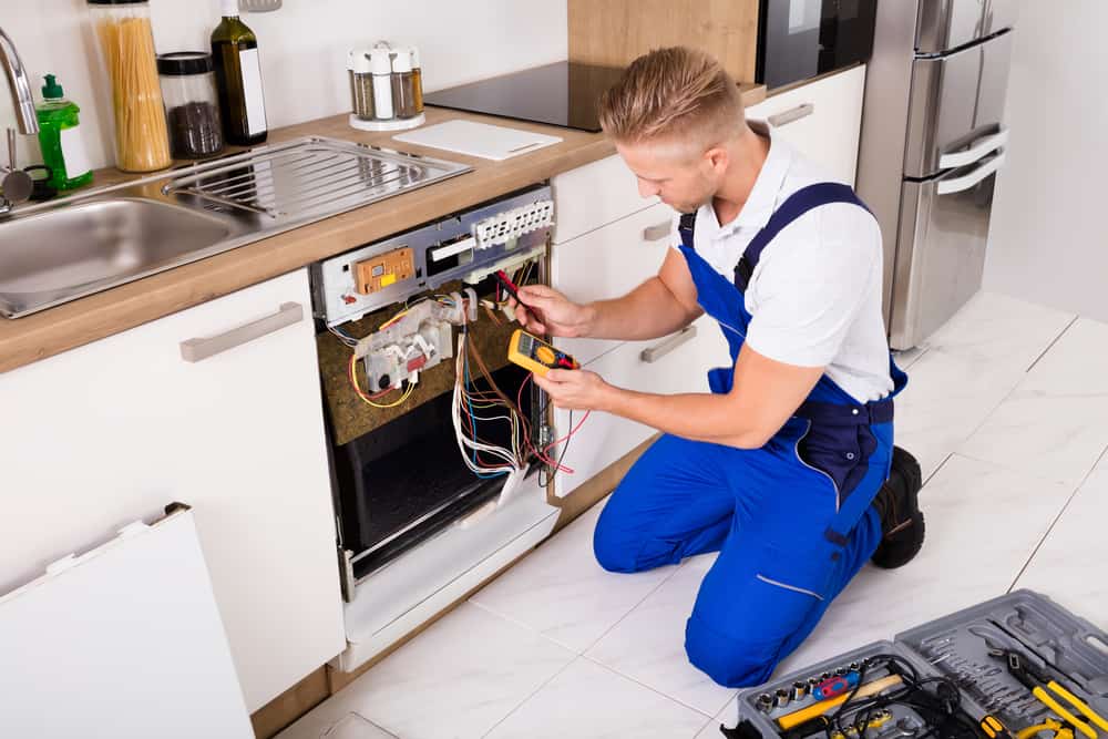 technician testing dishwasher in kitchen. Appliance Repair Queens, NY